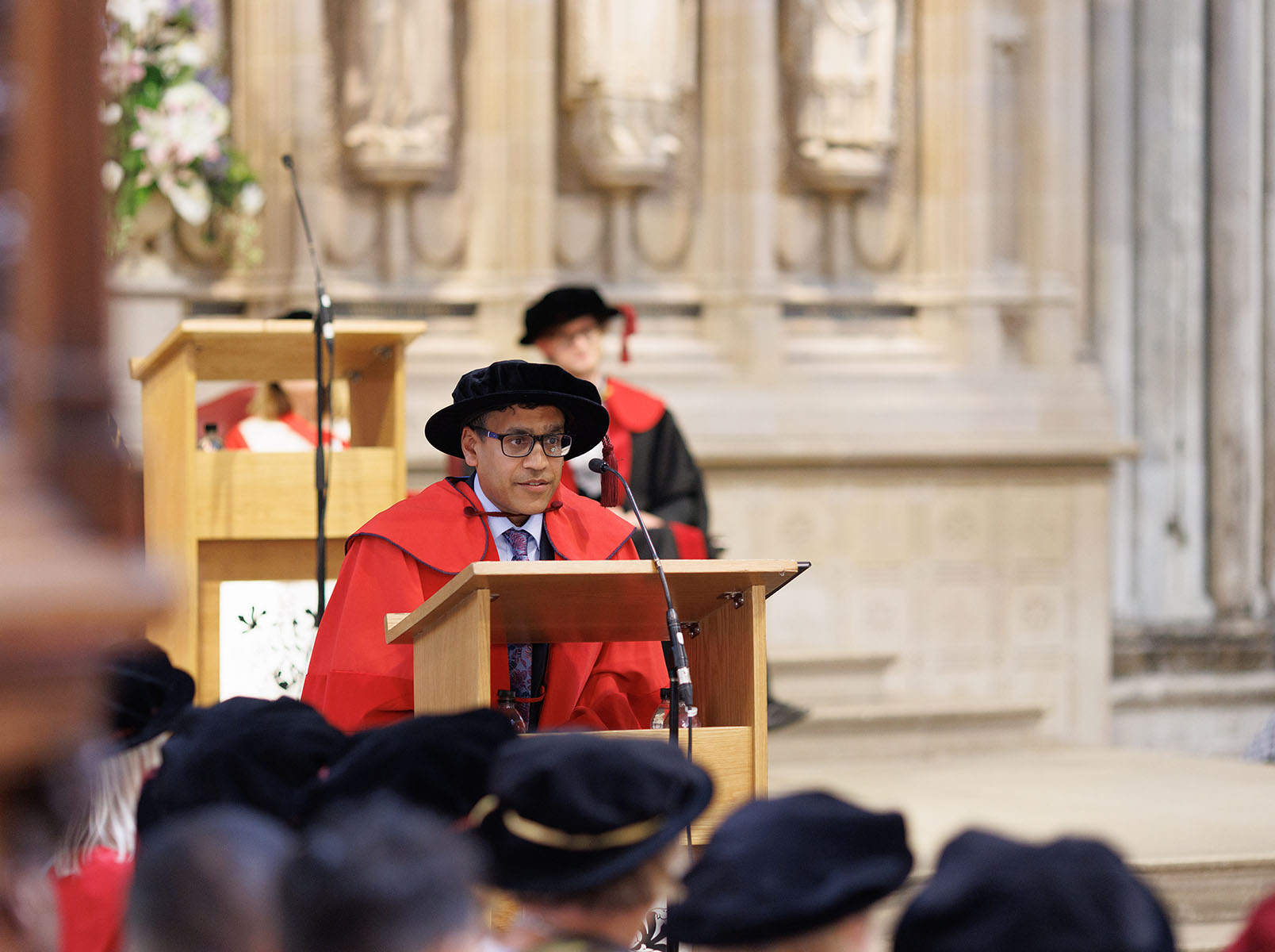 Dr Kush Kanodia speaking at a lectern giving a talk at a University graduation