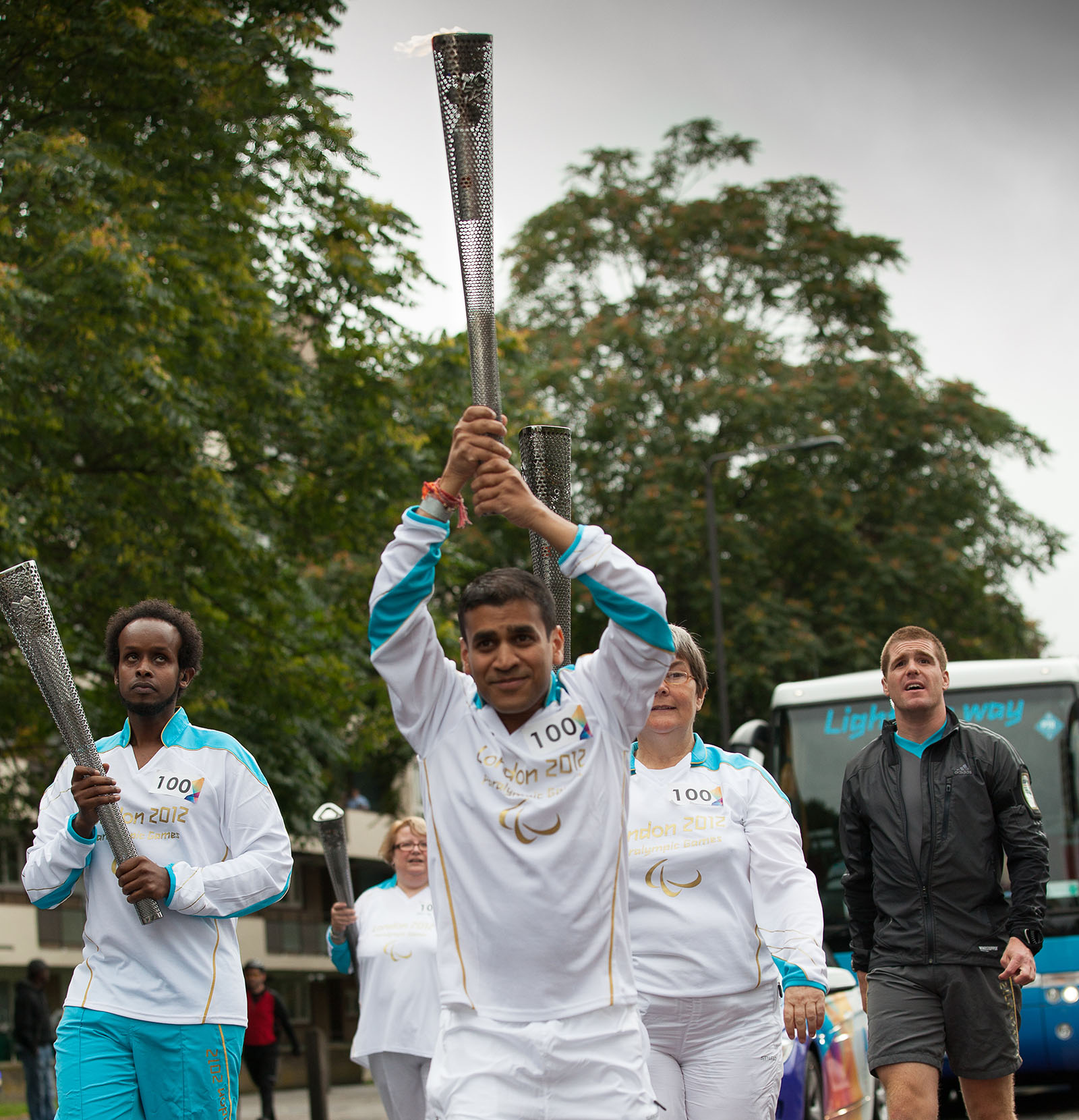 Dr Kush Kanodia carrying the Paralympic torch above his head