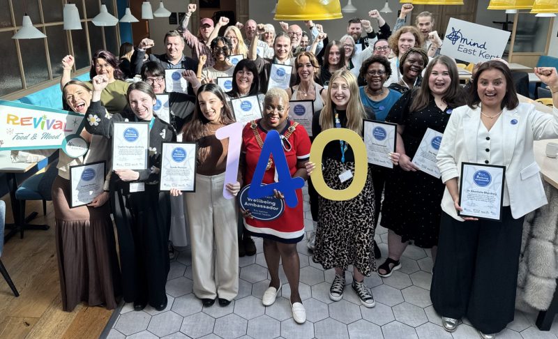 Two dozen East Kent Mind Wellbeing Ambassadors are cheering after receiving certificates and badges from the Lord Mayor of Canterbury Cllr Keji Moses at a special celebration event