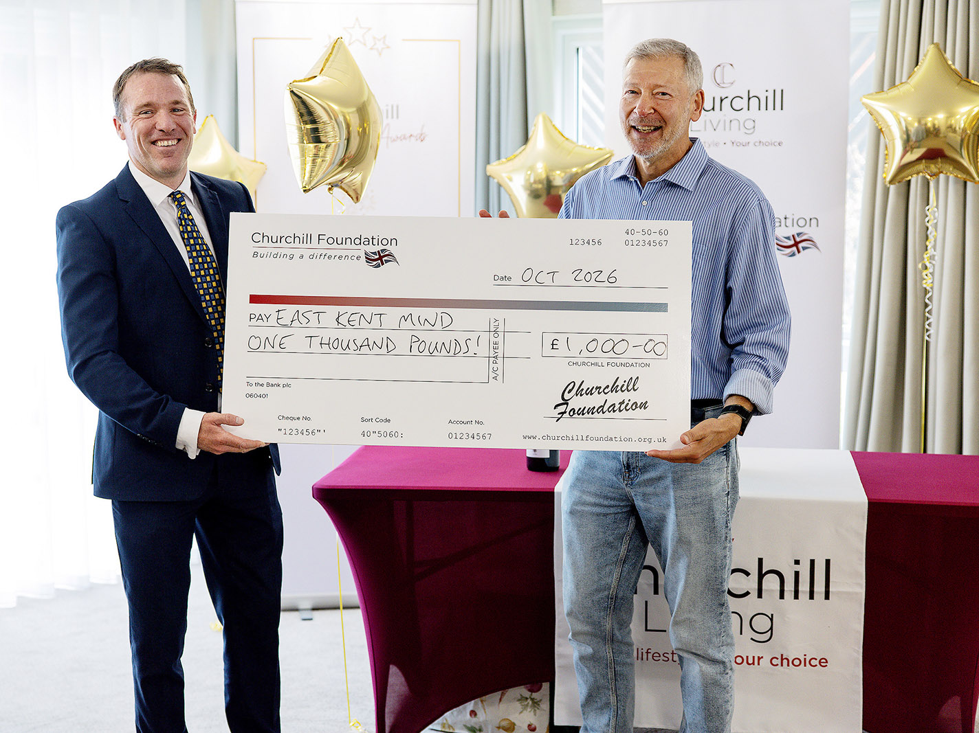 Simon Dolby is receiving a giant cheque from Churchill Living made out to East Kent Mind for £1,000